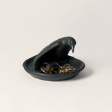 Black bird trinket dish filled with keys and jewelry.