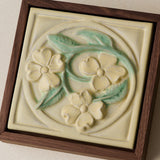 Close-up details of the sculpted tile, with visible carvings and layered glaze.