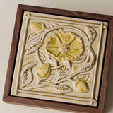 Close-up details of the sculpted tile, with visible carvings and layered glaze.