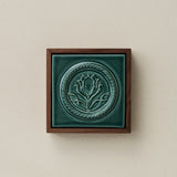 Sculpted decorative tile in wood frame by Rookwood