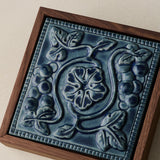 Close-up details of the sculpted tile, with visible carvings and layered glaze.