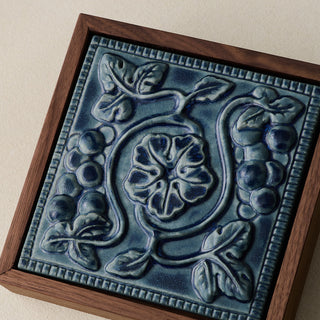 Close-up details of the sculpted tile, with visible carvings and layered glaze.