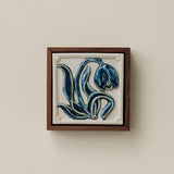 Sculpted decorative tile in wood frame by Rookwood