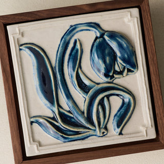 Close-up details of the sculpted tile, with visible carvings and layered glaze.
