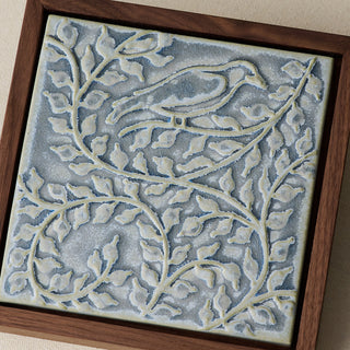 Close-up details of the sculpted tile, with visible carvings and layered glaze.