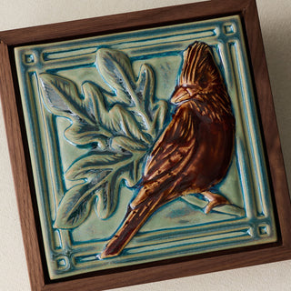 Close-up details of the sculpted tile, with visible carvings and layered glaze.