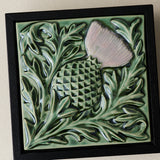 Close-up details of the sculpted tile, with visible carvings and layered glaze.