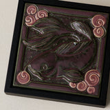 Close-up details of the sculpted tile, with visible carvings and layered glaze.