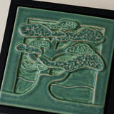 Close-up details of the sculpted tile, with visible carvings and layered glaze.
