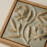Close-up details of the sculpted tile, with visible carvings and layered glaze.