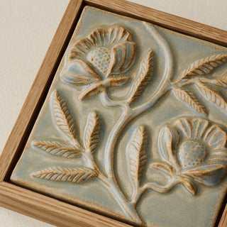 Close-up details of the sculpted tile, with visible carvings and layered glaze.