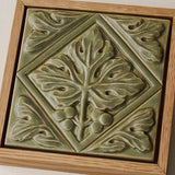Close-up details of the sculpted tile, with visible carvings and layered glaze.