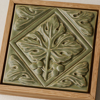 Close-up details of the sculpted tile, with visible carvings and layered glaze.
