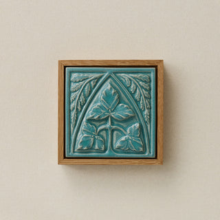 Sculpted decorative tile in wood frame by Rookwood