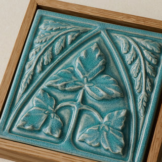 Close-up details of the sculpted tile, with visible carvings and layered glaze.