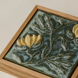 Close-up details of the sculpted tile, with visible carvings and layered glaze.