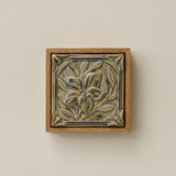 Sculpted decorative tile in wood frame by Rookwood