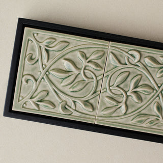 Close-up details of the sculpted tile, with visible carvings and layered glaze.