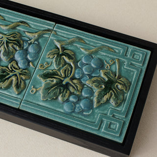 Close-up details of the sculpted tile, with visible carvings and layered glaze.
