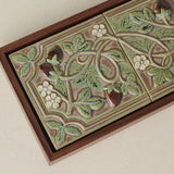 Close-up details of the sculpted tile, with visible carvings and layered glaze.