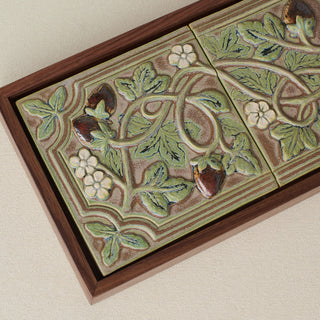 Close-up details of the sculpted tile, with visible carvings and layered glaze.