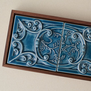 Close-up details of the sculpted tile, with visible carvings and layered glaze.